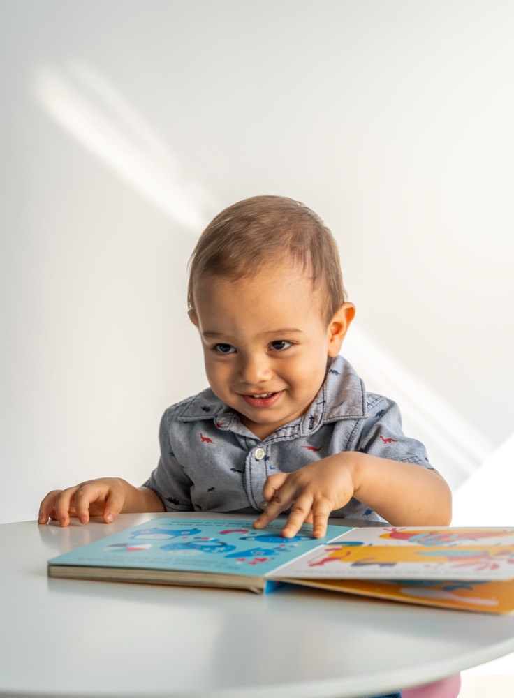 Bebé hojeando un libro infantil en la clínica