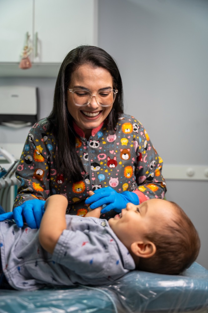 La doctora haciendo reír a un bebé en la camilla