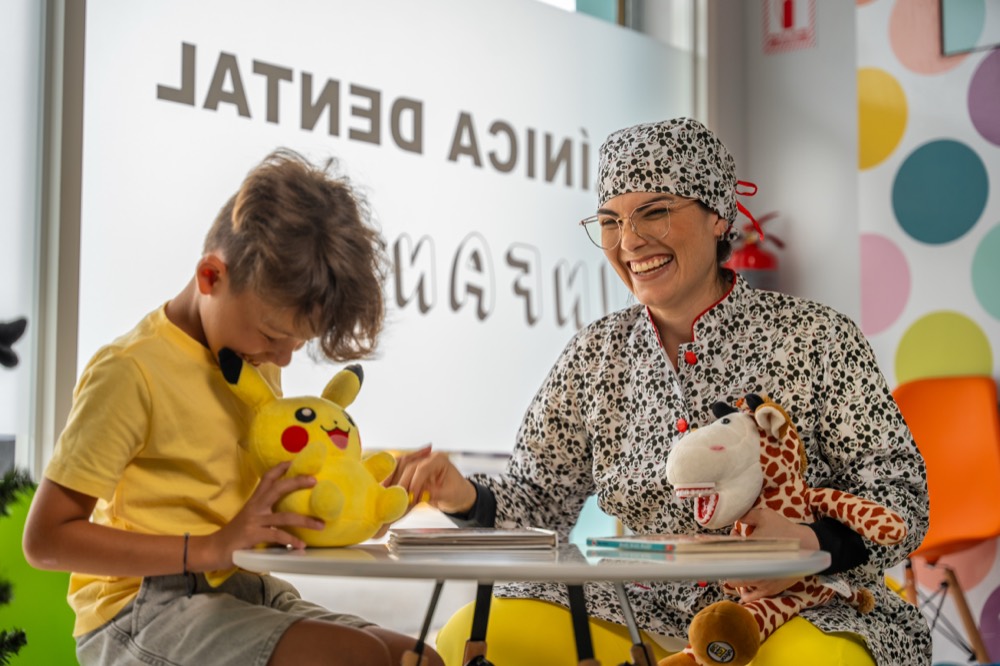 La doctora jugando con un niño y su peluche en la recepción